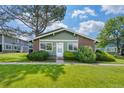 Charming front exterior with lush green lawn, mature tree, and well-maintained landscaping at 1216 S Uvalda St, Aurora, CO 80012