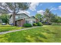 Charming front exterior with lush green lawn, mature tree, and well-maintained landscaping at 1216 S Uvalda St, Aurora, CO 80012