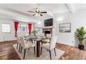 Bright dining room boasts a glass table, modern chairs, fireplace, and vaulted ceilings at 3762 S Fenton Way, Denver, CO 80235