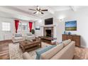 Cozy living room featuring bright armchairs, a fireplace, and hardwood flooring at 3762 S Fenton Way, Denver, CO 80235