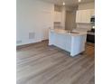 Modern kitchen features wood flooring, a center island, granite countertops and stainless steel appliances at 15277 Fillmore St, Thornton, CO 80602