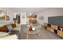 Bright living room featuring modern furnishings, adjacent kitchen, and neutral decor at 9300 E Center Ave # 2B, Denver, CO 80247