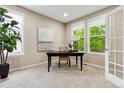 Bright and airy office space featuring carpet, neutral paint, large windows, and a dark wood desk, perfect for productivity at 2601 Pemberly Ave, Highlands Ranch, CO 80126