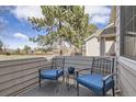 Cozy outdoor patio with comfortable blue cushioned chairs, a side table, and a stylish rug at 4027 E Geddes Cir, Centennial, CO 80122