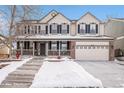 Two-story house with brick facade, attached garage, and snowy front yard at 10068 Darwin Ln, Highlands Ranch, CO 80130