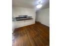 Living room featuring hardwood floors and a kitchen pass-through window at 1533 S Jamaica St, Aurora, CO 80012