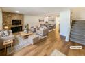 Virtually staged living room featuring a fireplace and hardwood floors at 1772 Robb St, Lakewood, CO 80215