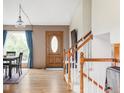 Inviting entryway with hardwood floors, staircase, and a wooden door with an oval glass insert at 11502 W 101St Avenue, Westminster, CO 80021