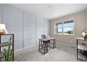 Bright home office with a light gray accent wall, plush carpet and window with a view at 652 Pinecliff Dr, Erie, CO 80516