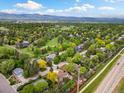 Expansive aerial view of the neighborhood, showcasing lush greenery, golf course, and mountain backdrop on a bright day at 4656 Tanglewood Trl, Boulder, CO 80301