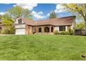 Charming ranch home with a lush front lawn, brick accents, and a covered front porch at 4656 Tanglewood Trl, Boulder, CO 80301