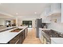 Open concept kitchen featuring a large center island, stainless appliances, and hardwood flooring throughout at 4656 Tanglewood Trl, Boulder, CO 80301