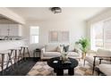 Inviting living room features neutral tones, plush seating, and a seamless flow into the kitchen area at 4555 Andes St, Denver, CO 80249