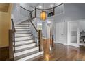 Elegant foyer with a curved staircase, hardwood floors, and a modern pendant light at 1193 Phipps Ct, Highlands Ranch, CO 80126