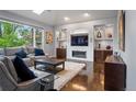 Comfortable living room with a fireplace, custom built-ins, and a large window at 1193 Phipps Ct, Highlands Ranch, CO 80126