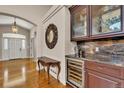 Elegant foyer features hardwood floors, a decorative mirror, and a built-in bar with a wine cooler at 11 Canon Pl, Greenwood Village, CO 80111