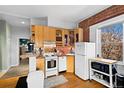 Efficient kitchen boasts wood cabinets, tile backsplash, and an adjacent dining area at 1450 N High St # 3, Denver, CO 80218