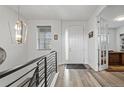 Bright foyer with wood flooring, featuring a modern light fixture and easy access to the study at 6728 Mentha Dr, Castle Rock, CO 80108