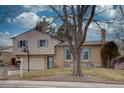 Charming two-story home with a combination of siding and brick, complemented by delightful blue shutters at 1549 S Evanston St, Aurora, CO 80012