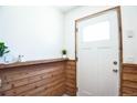 Inviting entryway featuring custom wood paneling, a white door, and natural light at 1641 S Idalia Cir # F, Aurora, CO 80017