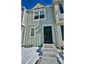 Attractive two-story townhome showcasing a light green exterior and snowy front yard at 1641 S Idalia Cir # F, Aurora, CO 80017