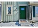 Stylish townhome featuring a light-green front door with black screen and light-green vertical siding and three concrete steps at 1641 S Idalia Cir # F, Aurora, CO 80017