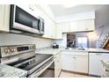 Modern kitchen with stainless steel appliances, granite countertops, and bright white cabinetry at 1641 S Idalia Cir # F, Aurora, CO 80017