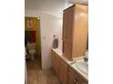 Bathroom with double sinks, wood cabinets, yellow accent wall and tile floors at 1888 S Jackson St # 404, Denver, CO 80210