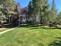 A spacious front yard with lush green grass and mature trees in a sunny, well-maintained neighborhood at 11576 E Bayaud Dr, Aurora, CO 80012