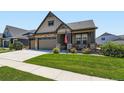 Charming home featuring stone accents, a two-car garage, and a cozy front porch at 7702 E 157Th Ave, Thornton, CO 80602