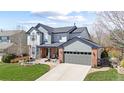 Attractive two-story home featuring mixed siding, manicured lawn, and a spacious driveway leading to the garage at 7106 Cerney Cir, Castle Pines, CO 80108
