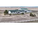 Charming exterior view of a white house with green roof and landscaping at 32350 E 137Th Way, Brighton, CO 80603