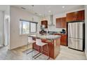 Kitchen island featuring a granite countertop, stainless steel appliances, ample cabinet space, and barstool seating at 2958 Syracuse St # 204, Denver, CO 80238