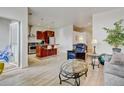 Open concept living area featuring a kitchen with an island, stainless appliances, and hardwood-style flooring at 2958 Syracuse St # 204, Denver, CO 80238
