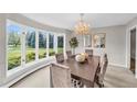 Elegant dining room featuring a bay window, chandelier, and ample natural light at 10 Martin Ln, Cherry Hills Village, CO 80113