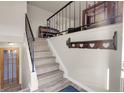 Well lit staircase leads to the second floor with updated railing and wood floors at 12829 E Oregon Dr, Aurora, CO 80012