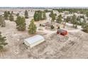 Wide aerial shot of property with large shed, red barn, and a house on grassy open land at 512 County Road 136, Elizabeth, CO 80107