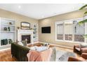 Cozy living room with a fireplace, built-in shelves, hardwood floors, and large windows at 529 Uinta Way, Denver, CO 80230