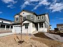 Charming two-story home featuring gray siding, white trim and brick accents, a covered porch, and a two-car garage at 4026 N Irvington St, Aurora, CO 80019
