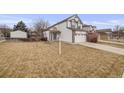 Daytime view of a charming two-story home with a well-manicured lawn and a convenient two-car garage at 5689 S Youngfield Way, Littleton, CO 80127