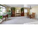 Large living room featuring neutral carpet, multiple bookshelves, and plentiful natural light at 4863 Quail Ct, Frederick, CO 80504