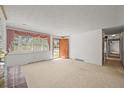 Inviting living room with large window and wooden door, seamlessly connecting to the outdoors at 5703 Field St, Arvada, CO 80002