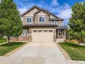 Inviting two-story house with a spacious driveway, beautiful stonework, and a cozy covered front porch at 30 Sun Up Ct, Erie, CO 80516