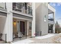 Close-up of a modern townhome showcasing a covered porch with seating, adding charm and functionality to the entrance at 4260 E Warren Ave # 5, Denver, CO 80222