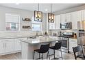 Bright kitchen features white cabinets, granite countertops, stainless steel appliances, and a center island with barstool seating at 4260 E Warren Ave # 5, Denver, CO 80222