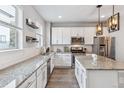 Well-lit kitchen with white cabinets, stainless steel appliances, and a granite island offers ample counter space at 4260 E Warren Ave # 5, Denver, CO 80222