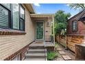 Welcoming entrance with steps leading to a charming brick home with vintage details at 1540 Filbert Ct, Denver, CO 80220