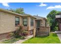 Inviting front yard with a brick house featuring roses, a green lawn, and a wood fence at 1540 Filbert Ct, Denver, CO 80220