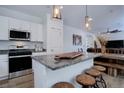 Kitchen featuring granite countertops, pendant lighting, stainless appliances, and wooden barstool seating at 23670 E 41St Ave, Aurora, CO 80019