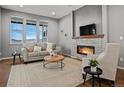 Cozy living room with stone fireplace, large windows, and comfortable seating at 2351 Lassen Ln, Castle Rock, CO 80109